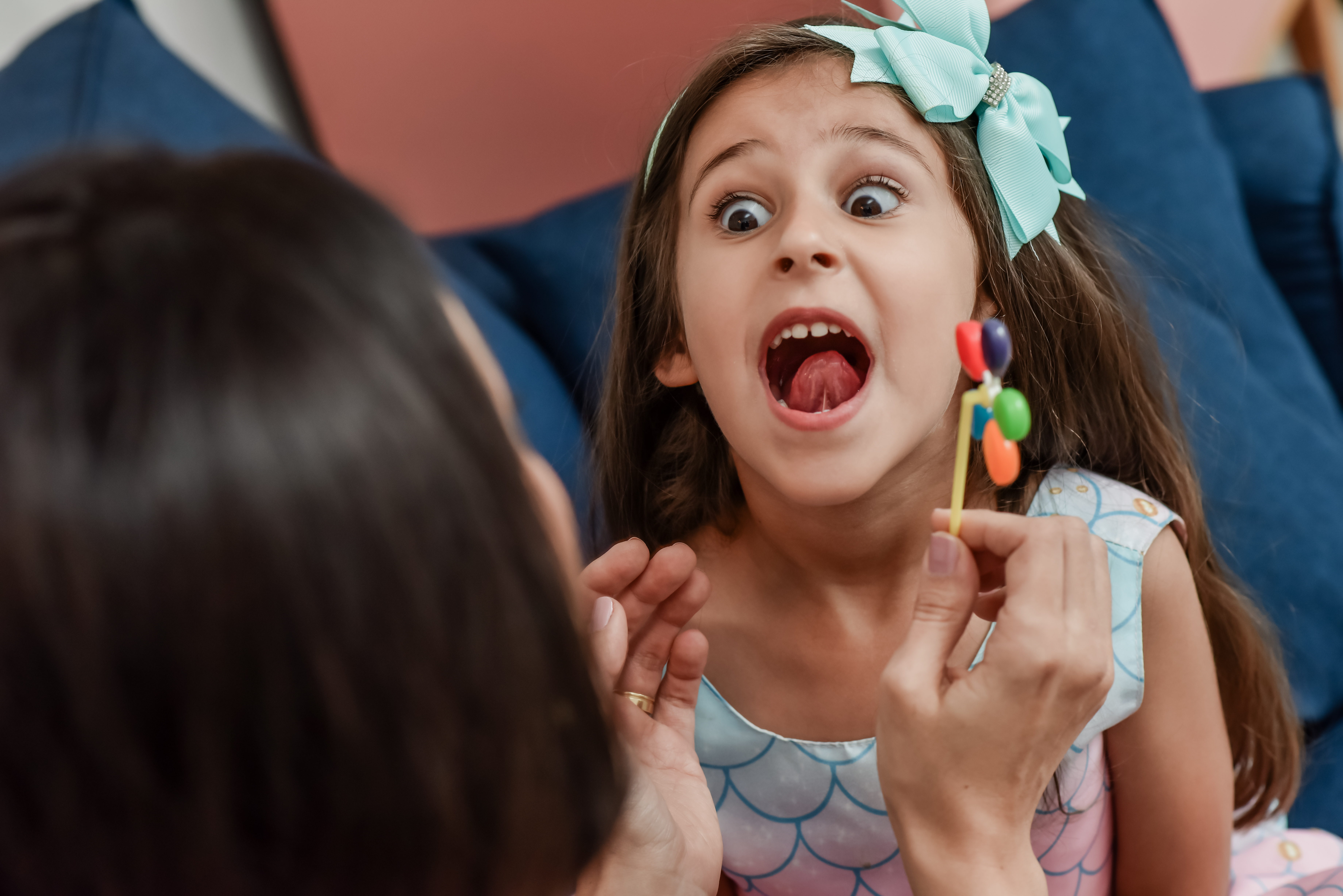 Fonoaudióloga realizando atividade lúdica com criança usando brinquedo colorido